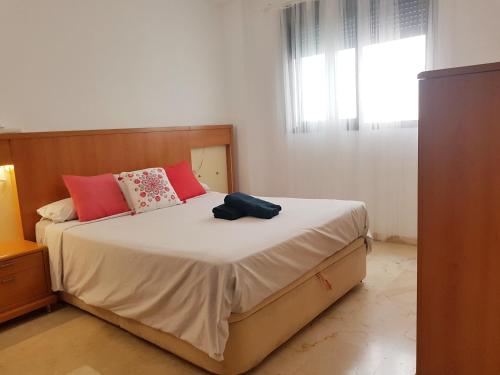休达Bel appartement au centre ville et de la plage的一间卧室配有一张带红色枕头的大床