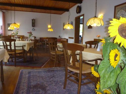 耶弗尔Hotel-Pension Stöber的一间带桌椅和向日葵中心的餐厅