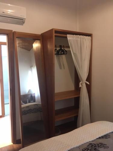 普拉亚多Praia do Forte Apartamento Fantástico的一间卧室配有带镜子的梳妆台和一张床