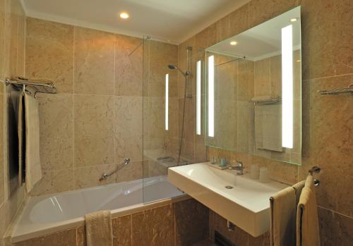 阿玛考德佩拉佩斯塔纳维京海滩Spa度假酒店的带浴缸、水槽和镜子的浴室