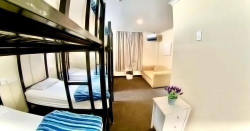 罗托鲁瓦罗托鲁瓦市中心背包客旅舍的带三张双层床和一张沙发的房间