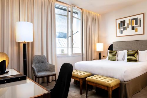 巴黎剑锷酒店的酒店客房配有一张床、一张桌子和一把椅子。