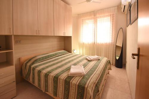 维拉西米乌斯Residenza Le Due Palme的一间卧室配有一张带绿色和白色毯子的床