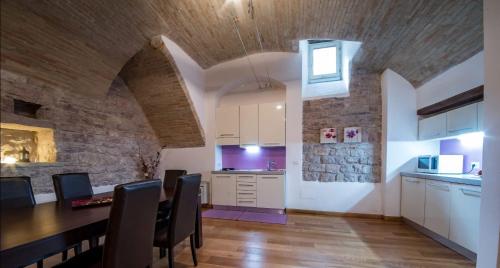 阿西西Appartamento Sant'Apollinare的一间厨房和带石墙的用餐室