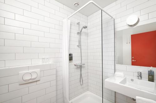 霍芬Höfn - Berjaya Iceland Hotels的带淋浴和盥洗盆的白色浴室