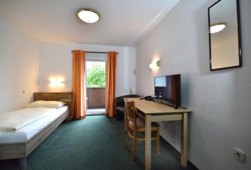 魏勒格Hotel&Wirtshaus Sonne的客房设有一张床、一张桌子和一台电脑