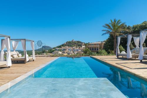 卡普德佩拉Hotel Creu de Tau Art&Spa-Adults only的度假村旁的游泳池,带白色椅子