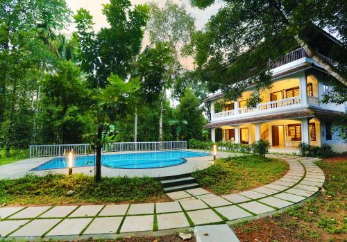 科钦Once Upon The River, Aluva - Near Cochin International Airport的一座房子前面设有游泳池
