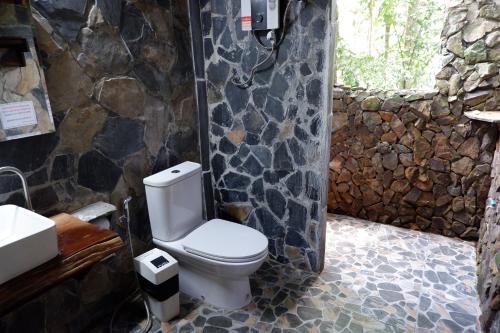 考索考索自然度假酒店的一间带卫生间和石墙的浴室