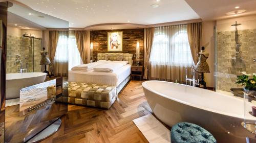 阿芬瑟尔Bergergut Geniesserhotel的带浴缸、床和浴缸的浴室