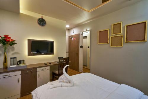 浦那Tranquil La Casa的一间卧室配有一张床、一张书桌和一台电视。