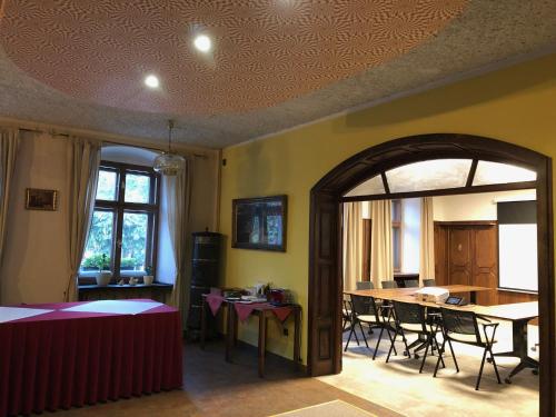霍捷博日贝纳旅馆的一间带桌椅的房间和一间用餐室