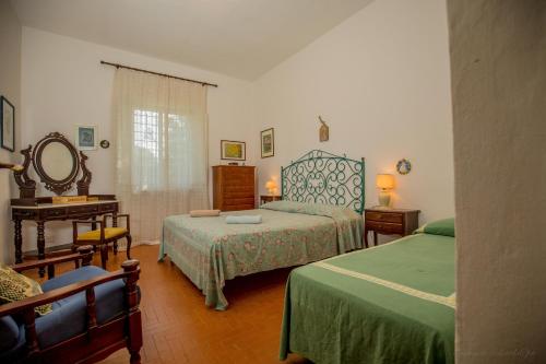 圣托斯特凡诺港Mediterranean Villa的一间卧室配有两张床、一张桌子和一面镜子