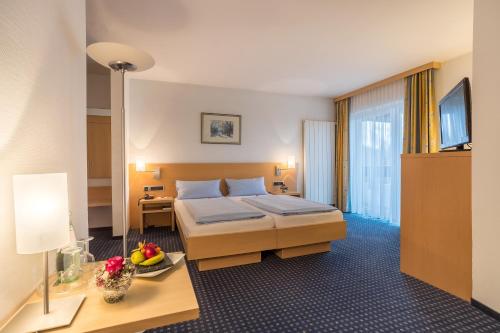 格林贝格格伦贝格健身酒店的酒店客房配有一张床、一张书桌和一台电视。