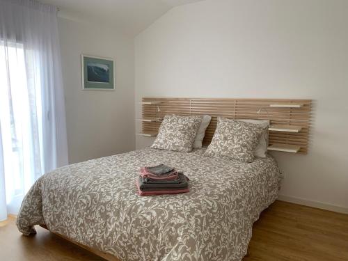 波尔尼克LE CLOS SAINTE MARIE的一间卧室配有带枕头和毛巾的床。