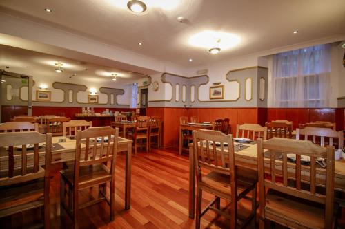 格拉斯哥Charing Cross Hotel的用餐室配有木桌和椅子