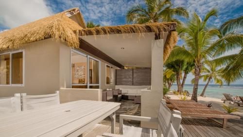 拉罗汤加皇冠海滩度假村和温泉中心的海滩上带桌椅的房子