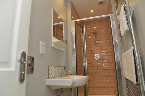圣艾夫斯10B Old green Chamber City center apartment, spacious and free parking!的一间带水槽和淋浴的浴室