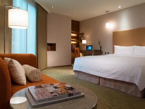花莲市经典假日饭店的酒店客房设有一张大床和一张沙发。
