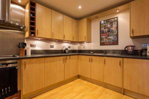 南安普敦Cruisers Haven的厨房配有木制橱柜和黑色台面