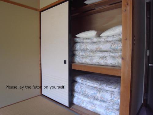 南木曾町东光味噌日式旅馆的客房设有一个配有床垫的衣柜。