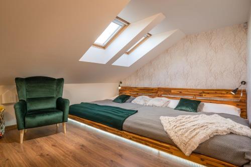 多纳瓦利Apartmanica Residence 606的一间卧室配有一张床和一把绿色椅子