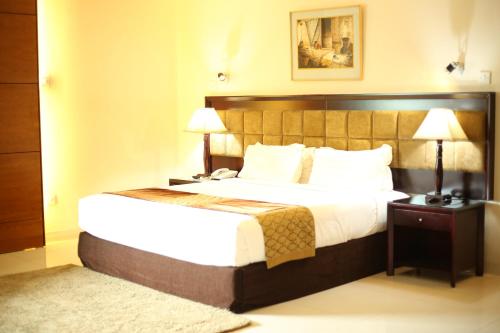 吉大港THE AVENUE HOTEL & SUITES的酒店客房,配有一张床和两盏灯