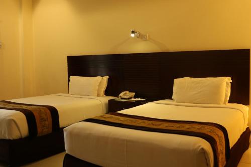 吉大港THE AVENUE HOTEL & SUITES的酒店客房带两张床和电话