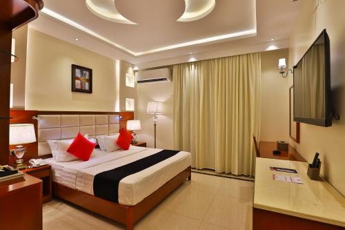 泰布克Dreams Houses furnished Suites的一间卧室配有一张带红色枕头的床和电视。