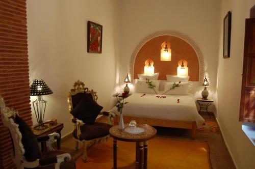 马拉喀什厄尔帕夏酒店的卧室配有1张床、1张桌子和1把椅子