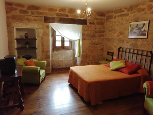 PedrazalesLa Posada de Pedrazales的卧室配有一张床和一张桌子及椅子