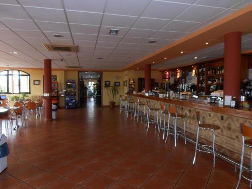 比利亚尔潘多Hotel Cañada Real的餐厅内的酒吧配有椅子和柜台