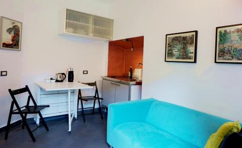 米兰拉万代巷一室公寓的一间带蓝色沙发的客厅和一间厨房