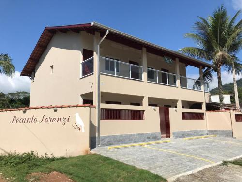 乌巴图巴Recanto Lorenzi - Apartamentos的前面有棕榈树的建筑