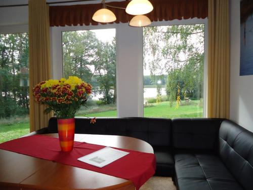 Reimershagen叙维森菲瑞恩哈森酒店的一张带桌子和花瓶的黑色沙发