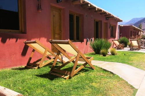 蒂尔卡拉Casatilcara Cabañas的坐在房子外的几张木凳