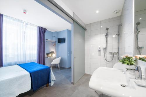 比亚里茨萨菲尔酒店的配有床、淋浴和盥洗盆的浴室