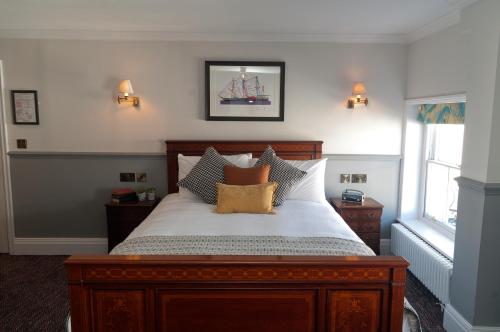 伦敦Admiral Hardy的一间卧室配有一张带枕头的大型木制床。