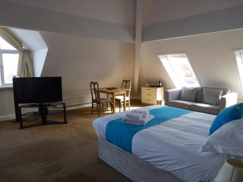 海斯船屋酒店的一间卧室配有一张床、一台电视和一张桌子