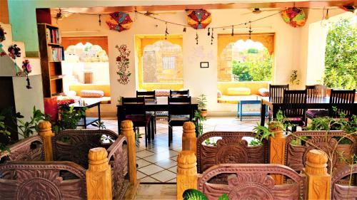 斋沙默尔The Wanderlust Guest House & Safari的客厅配有桌椅和钢琴