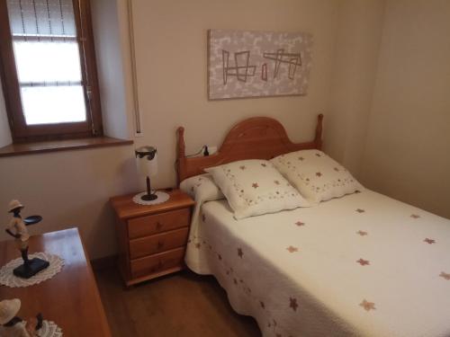 JaurrietaCasa Ayabe的一间卧室配有一张带木制床头板的床和窗户。