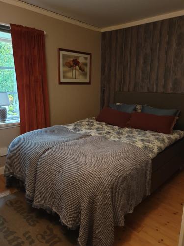 GlanshammarSpiragården的一间卧室配有一张带床罩的床和窗户