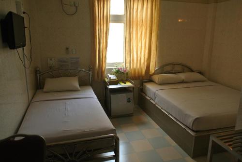 仰光秀烟陶酒店的小型客房 - 带2张床和窗户