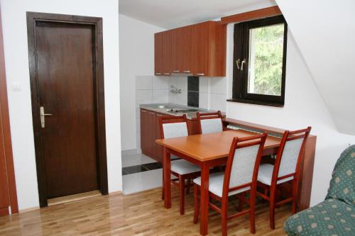 科帕奥尼克苏木斯卡维奇1号公寓式酒店的一个带木桌和椅子的小厨房