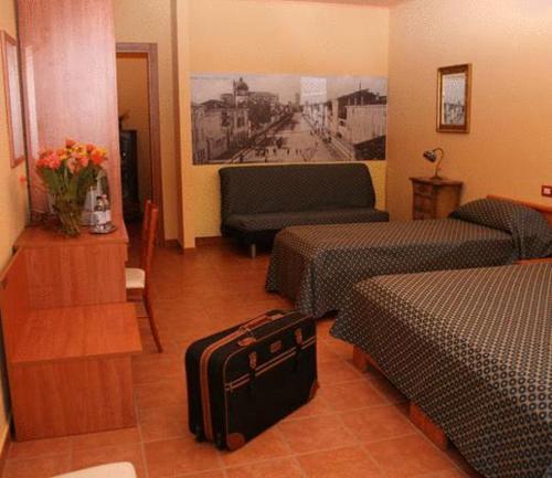 维罗纳自由镇阿尔贝格科特安提卡酒店的酒店客房带两张床和行李箱