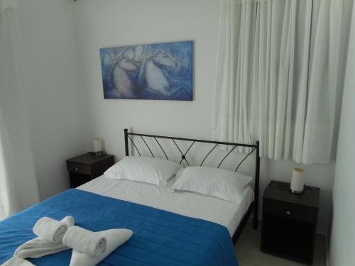 阿齐亚·佩拉加·基西拉阿纳托利公寓的一间卧室配有一张床,上面有两条毛巾