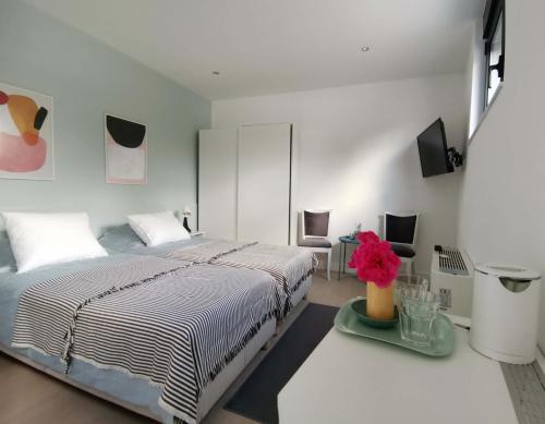瓦列沃Nana / Sobe & Apartmani的白色卧室配有床和桌子