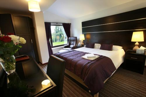 布里真德伊维尼农场旅馆的酒店客房设有一张大床和一张桌子。