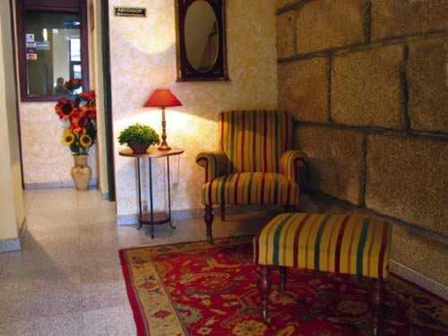 维戈维哥卡萨布兰卡酒店的一间带椅子、桌子和灯的房间
