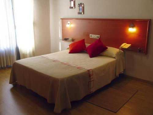 维戈维哥卡萨布兰卡酒店的一间卧室配有一张带红色枕头的大床